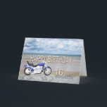 16th födelsedagkort med en motorisk cykel kort<br><div class="desc">En motorisk blått cyklar anseende på en strand med fluffiga moln i himmlen. Skriftlig grattis på födelsedagen i sten reflekterad i vatten som ljuger på sanden.</div>
