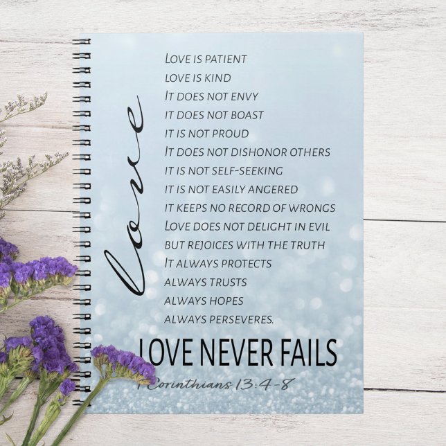 1 Corinthians 13 Kärlek är Bible Verse Anteckningsbok (Corintians 13:4-8 Love Never Fails Notebook on White Table with Purple Flowers)