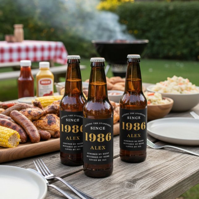 40:e födelsedag Namn 1986 Svarta Guld-Elegantens C Ölflaska Etikett (1986 beer bottle labeled beer on a BBQ table.)
