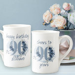 90:e födelsetal till 90 års Blommigt nummer Benporslin Mugg<br><div class="desc">90:e födelsedag i mugg, med fullt redigerbara formuleringar för att anpassa sig som du vill, som "grattis på födelsedagen [namn]" och/eller "jubla till 90 år". Konstruktionens nummer 90, dekorerat med ro-knoppar, blomblommor och löv i kustblått och sand. Diskret feminin- och elegant-design med vattenfärgsarrangemang, färgstänk och penseldrag. Perfekt för 90:e födelsedagskalender...</div>