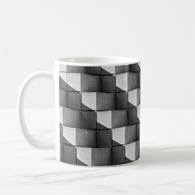 A ansikte i skulpturen "Four Sided Pyramid" i Kaffemugg (Vänster)