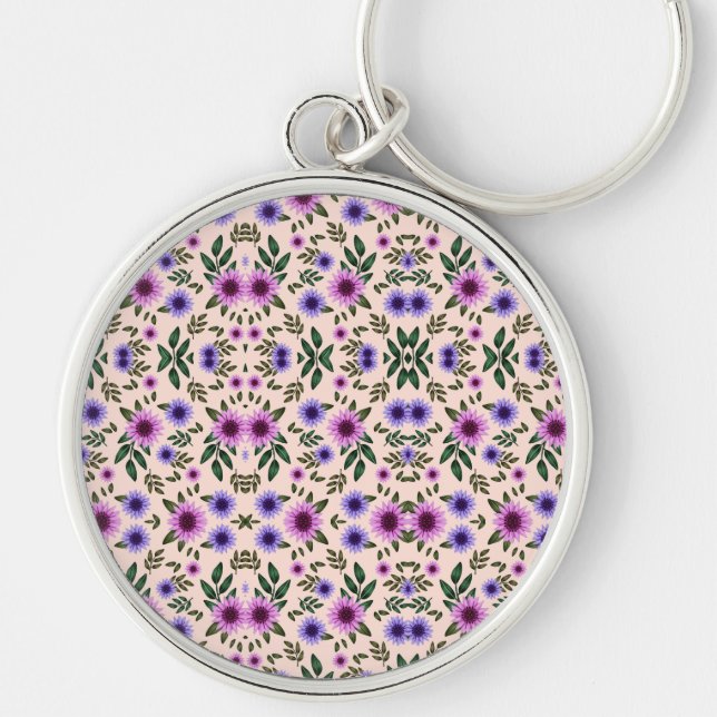 A round keychain features a detailed floral  rund silverfärgad nyckelring (Framsidan)
