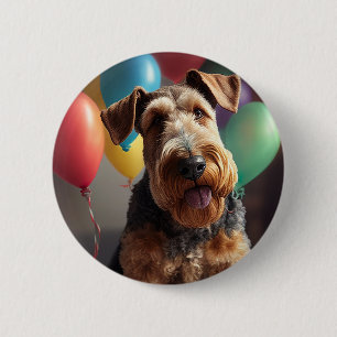 Airedale-hund med kakor och ballonger knapp