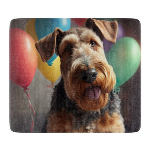Airedale hund med tårta och ballonger