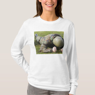 Airmanen kryper till och med ett vått fält tee shirt