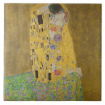 Älskare Kissing Embrace av Gustav Klimt Kakelplatta<br><div class="desc">Solljus blundar från det virvlande guldomfamning som omger älskare i Gustav Klimts mästerverk, The Kiss. Scenen är en paradox med intimitet och isolering. Paret står på en avgrund, en fält av färgstarka blommor på fötterna, men ändå är de omedvetna mot omvärlden. Deras blickar är låsta, deras kroppar är sammanflätade i...</div>
