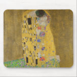 Älskare Kissing Embrace av Gustav Klimt Musmatta<br><div class="desc">Solljus blundar från det virvlande guldomfamning som omger älskare i Gustav Klimts mästerverk, The Kiss. Scenen är en paradox med intimitet och isolering. Paret står på en avgrund, en fält av färgstarka blommor på fötterna, men ändå är de omedvetna mot omvärlden. Deras blickar är låsta, deras kroppar är sammanflätade i...</div>