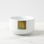 Älskare Kissing Embrace av Gustav Klimt Soppmugg<br><div class="desc">Solljus blundar från det virvlande guldomfamning som omger älskare i Gustav Klimts mästerverk, The Kiss. Scenen är en paradox med intimitet och isolering. Paret står på en avgrund, en fält av färgstarka blommor på fötterna, men ändå är de omedvetna mot omvärlden. Deras blickar är låsta, deras kroppar är sammanflätade i...</div>