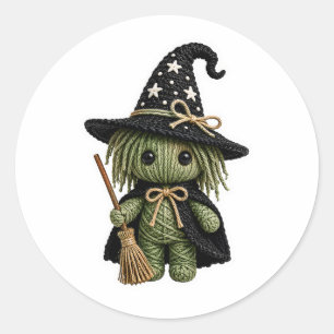 Amigurumi-stil sydd grön häxa med kvast  runt klistermärke