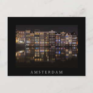 Amsterdamhus med färgad ljus på natten vykort