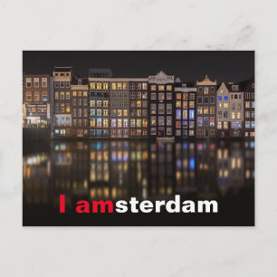 Amsterdamhus med färgad ljus på natten vykort