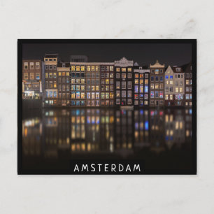 Amsterdamhus med färgad ljus på natten vykort