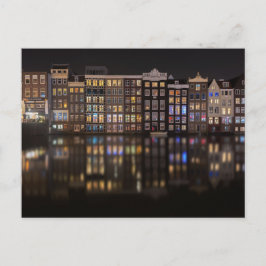 Amsterdamhus med färgad ljus på natten vykort