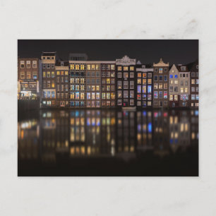 Amsterdamhus med färgad ljus på natten vykort