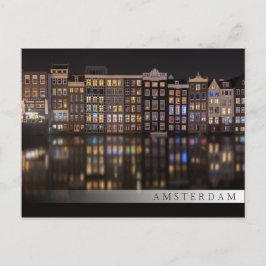 Amsterdamhus med färgad ljus på natten vykort