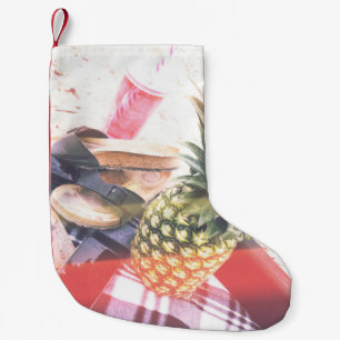 Ananas bredvid mobil och högtalare liten julstrumpa