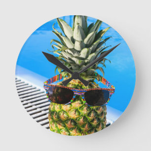 Ananas som ha på sig solglasögon på simbassäng rund klocka