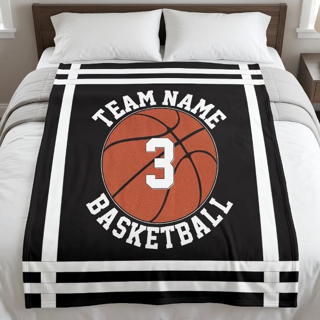 Anpassat namn på basketlag & spelarens nummersport fleecefilt (Personalized basketball blankets with custom team name and player number, on bed.)
