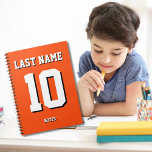 Anpassningsbarnas Orange Efternamn Sports Jersey-n Anteckningsbok<br><div class="desc">Namn,  antal och skugga är anpassade så att du kan göra en sportig,  men ändå användbar bärbar dator unik och matcha ditt favoritidrottslag färg eller rumsdekoration. Orangens bakgrund.</div>
