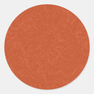 Apelsinorange texturerad yta med virvlande mönster runt klistermärke