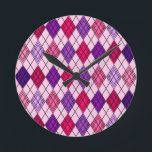 Art Deco Argyle  Rund Klocka<br><div class="desc">Den här väggklockan har en konsdeco-design av diamantformer som är tillverkade av överlappande vinklar i färgad av svart linjer i skuggor av lila och rosa med diagonalt svart linjer skapar designen som argyle</div>