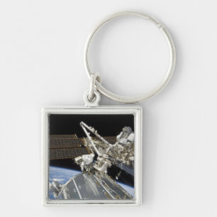Astronaut utför en serie av uppgifter fyrkantig silverfärgad nyckelring