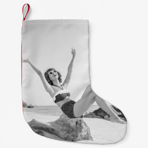 Attraktiv ung kvinna i bikini på beachvinta liten julstrumpa