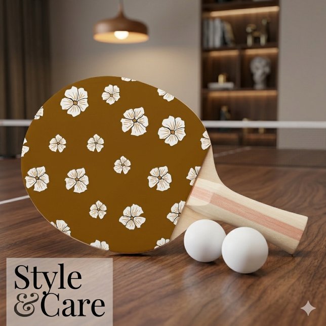 Attraktivt blommönster på brunt pingisracket (Attractive Floral Pattern on Brown Ping Pong Paddle)