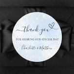 Baby blue silver hjärttack bröllop runt klistermärke<br><div class="desc">En ljus blå himmel som bakgrund,  dekorerad med faux silver glitter. Med texten: Tack för att ni delar vår speciella dag,  med ett litet hjärta. Anpassa och lägg till namnen.</div>
