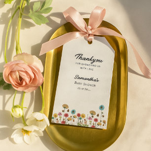 Baby i tack för blommor i blomman i vilden presentetikett