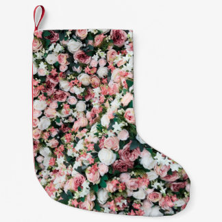 Bakgrund av ljusa, färgstarka artificiella blommor liten julstrumpa