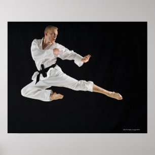 Barn bemannar att utföra karate sparkar på svart poster