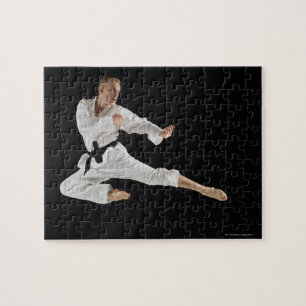 Barn bemannar att utföra karate sparkar på svart pussel
