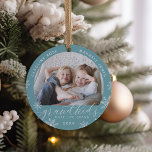 Barnbarn Make Life Grand Photo Julgransprydnad Keramik<br><div class="desc">Skapa en söt gåva till en älskad mormor eller morfar med detta vackra keramiska fotoornament. "Barnbarn gör livet stort" visas längs grund med vita snöflingor. Anpassa med året under och barnbarnbarnens namn krymper överst. Lägg till ett andra foto på baksidan.</div>