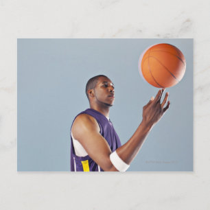 Basketbollspelare som balanserar boll på ena finge vykort
