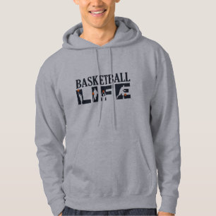 Basketbollspelare som borrar med orange boll hoodie