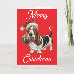 Basset Hound i Santa mössa present i munnen Kort