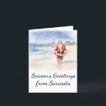 Beach Santa Watercolor-julkort Helgkort<br><div class="desc">Julkortet visar en avslappnad tomt som har en lång promenad på stranden. Anpassa det här julkortet för att spegla din favoritstrandstad!</div>