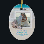 Beach Wedding Keepsaké Photo Ornament<br><div class="desc">Behåll bröllop med ett strandtema. Lägg till en bild till denna ovala,  keramiska ornament och anpassa med text på båda sidor. Tropiska sjöceller dekorerar ram och bakgrundsbilden är havets vatten och strandsand. Ställe namn,  bröllop,  datum på fram- och bestämmelseorten på baksidan.</div>
