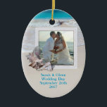 Beach Wedding Keepsaké Photo Ornament<br><div class="desc">Behåll bröllop med ett strandtema. Lägg till en bild till denna ovala,  keramiska ornament och anpassa med text på båda sidor. Tropiska sjöceller dekorerar ram och bakgrundsbilden är havets vatten och strandsand. Ställe namn,  bröllop,  datum på fram- och bestämmelseorten på baksidan.</div>