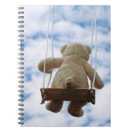 Beertje op schommel met bewolkte blauwe lucht. anteckningsbok