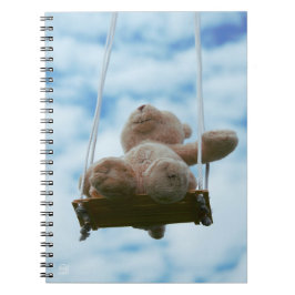 Beertje op schommel met bewolkte blauwe lucht. anteckningsbok