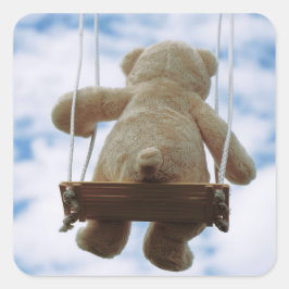 Beertje op schommel met bewolkte blauwe lucht. fyrkantigt klistermärke