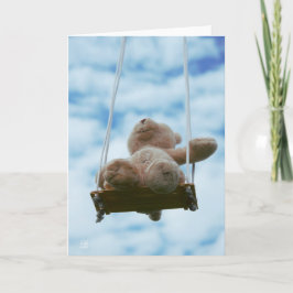 Beertje op schommel met bewolkte blauwe lucht. helgkort