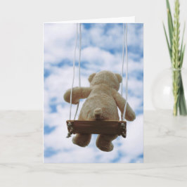 Beertje op schommel met bewolkte blauwe lucht. helgkort