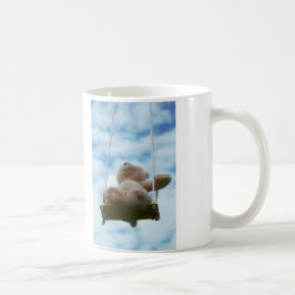 Beertje op schommel met bewolkte blauwe lucht. kaffemugg