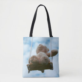 Beertje op schommel met bewolkte blauwe lucht. tygkasse