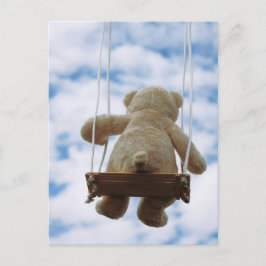 Beertje op schommel met bewolkte blauwe lucht. vykort