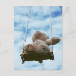 Beertje op schommel met bewolkte blauwe lucht. vykort