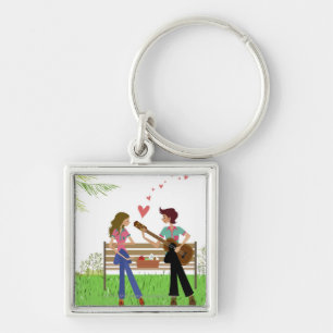 Bemanna att leka gitarren med en kvinna bredvid fyrkantig silverfärgad nyckelring